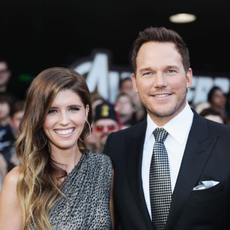 Chris Pratt in a black suit poses with wife Katherine Schwarzenegger.